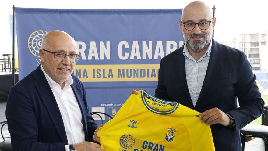 El presidente del Cabildo de Gran Canaria, Antonio Morales, posa junto al consejero de Deportes, Aridany Romero, con la elástica de la UD del Mundial.  | | LA PROVINCIA / DLP