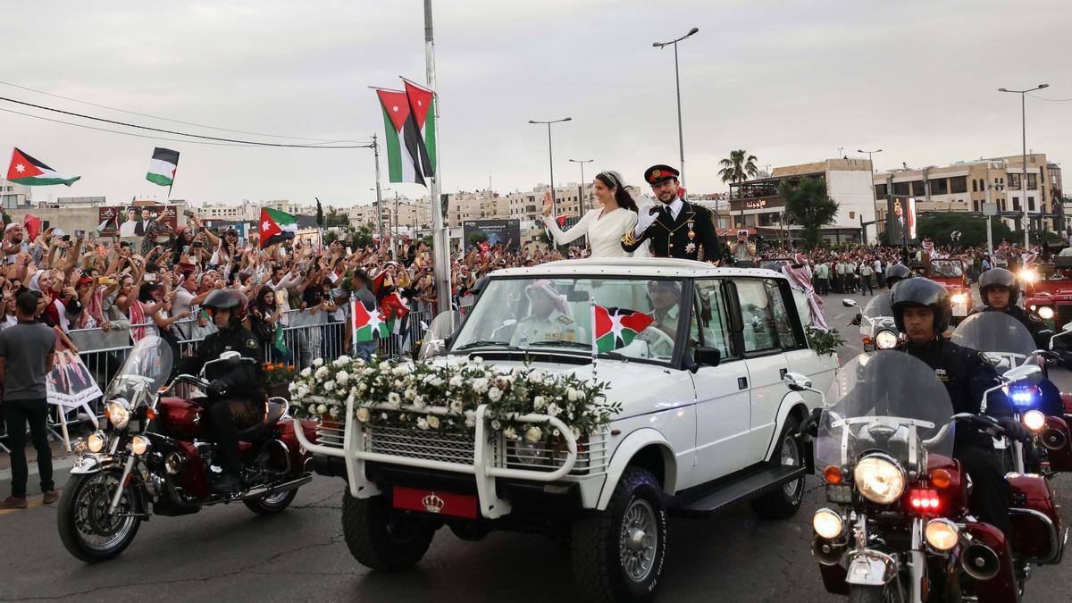  El príncipe heredero jordano Hussein y su esposa, la princesa Rajwa Al Saif , de Arabia Saudita, saludan a las personas congregadas tras la boda real en Amman, Jordania.