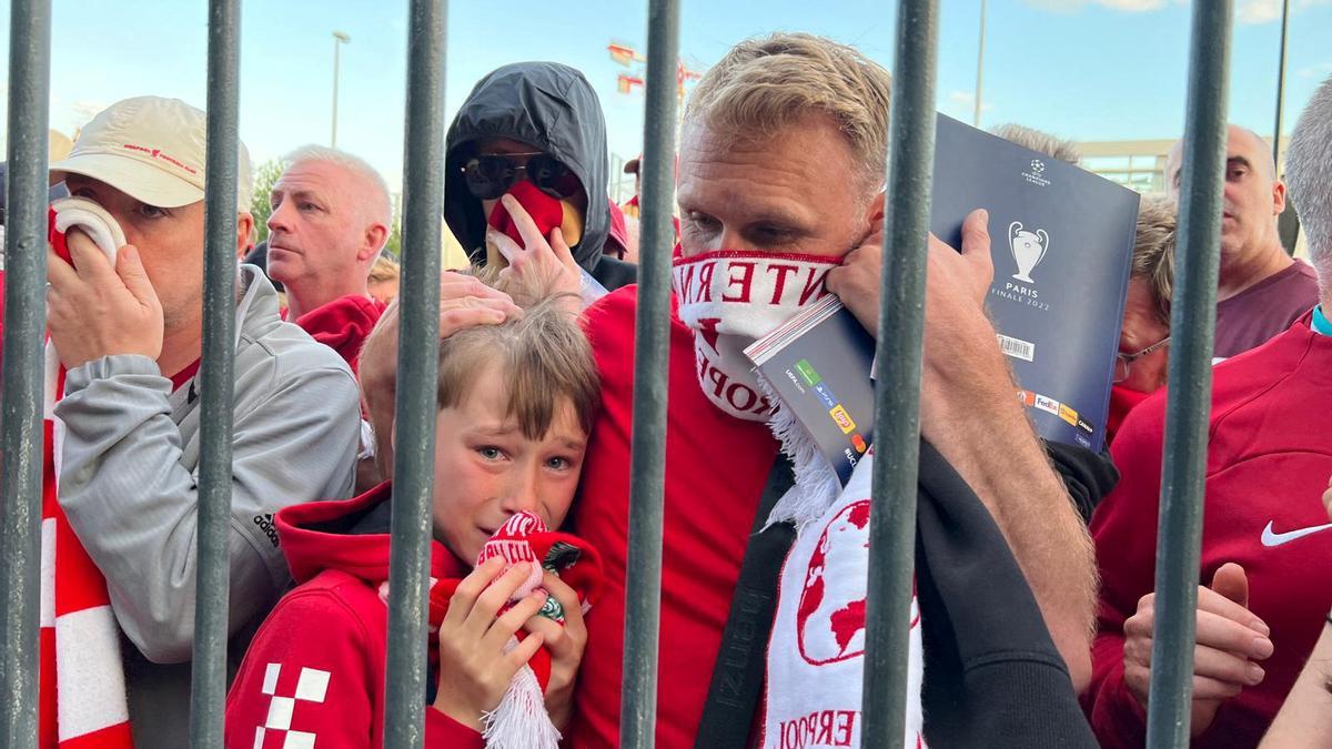 Hinchas del Liverpool se protegen de gases lacrimógenos en los accesos al Stade de France, antes de la final de la Champions.