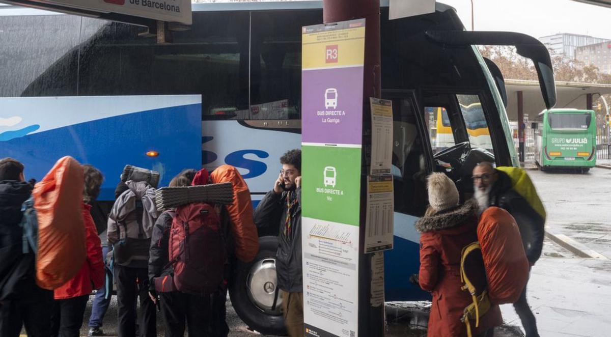 Una trentena de  passatgers espera davant un tren sense servei a  l’estació de Sants, ahir.