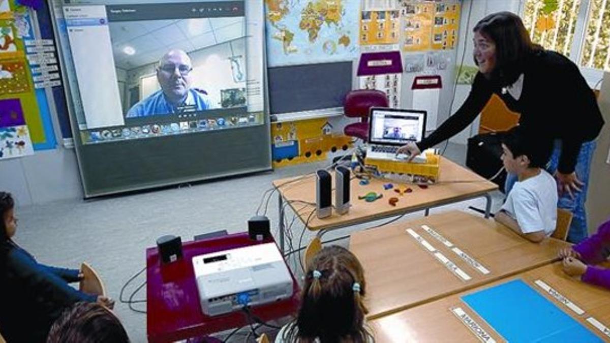 ACTIVIDAD 3 A la izquierda, niños de P-4 del CEIP Sant Martí muestran un transbordador de papel que les regaló la científica Alina Hirschmann. Ahora se turnan para llevárselo a casa. Arriba, la maestra Esther Manchón ayuda a un alumno a lanzar un coh