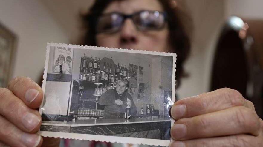 Pilar Blanco sostiene una foto de su abuelo Luis González hecha en la barra del Bar López.  // Bernabé/Gutier