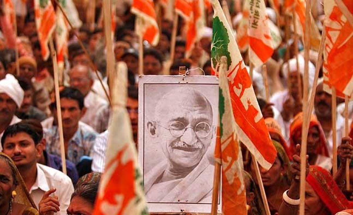 Un granjero sostiene un retrato de Mahatma Gandhi durante una marcha de protesta contra las políticas de industrialización del Gobierno, en Gandhinagar en el estado de Gujarat (India)