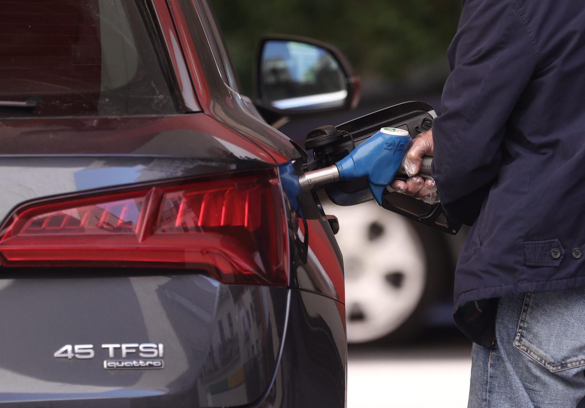 Archivo - Un hombre inyecta carburante a su coche