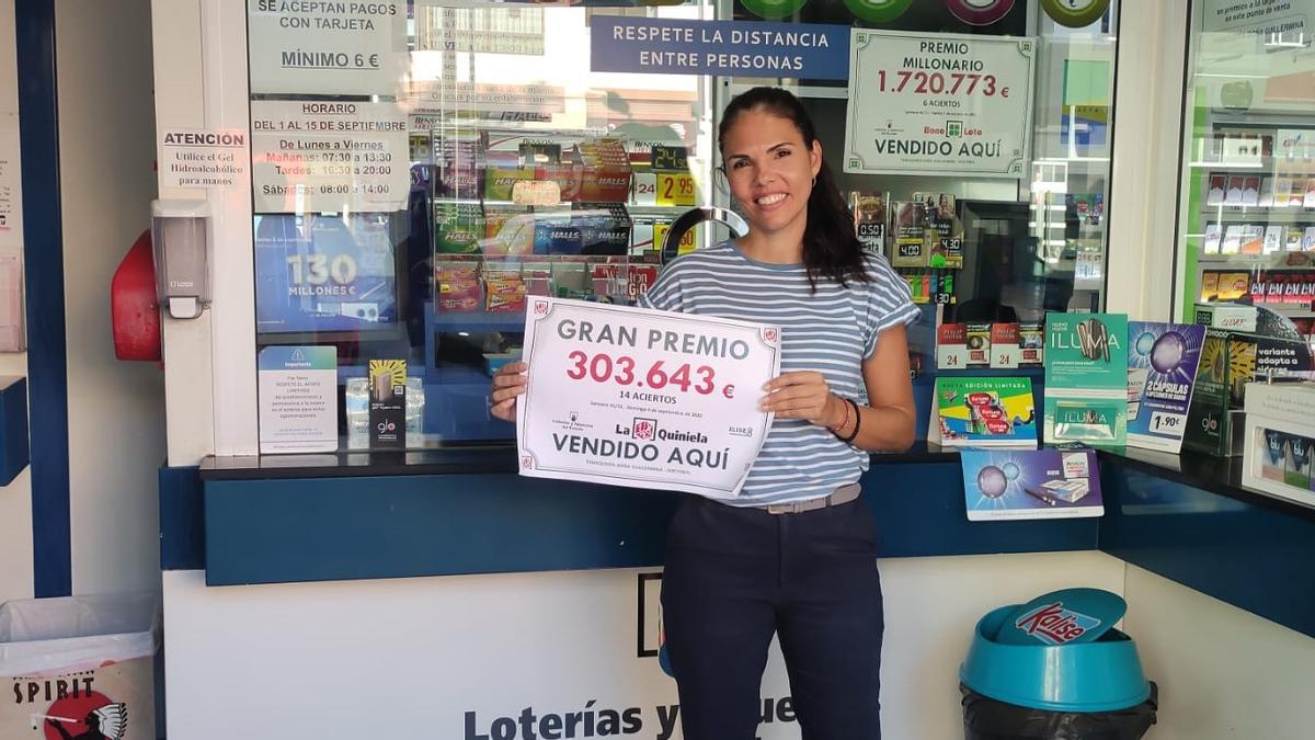 Una trabajadora de la Tabaquería Doña Guillermina de El Doctoral muestra el premio de 14 aciertos de La Quiniela