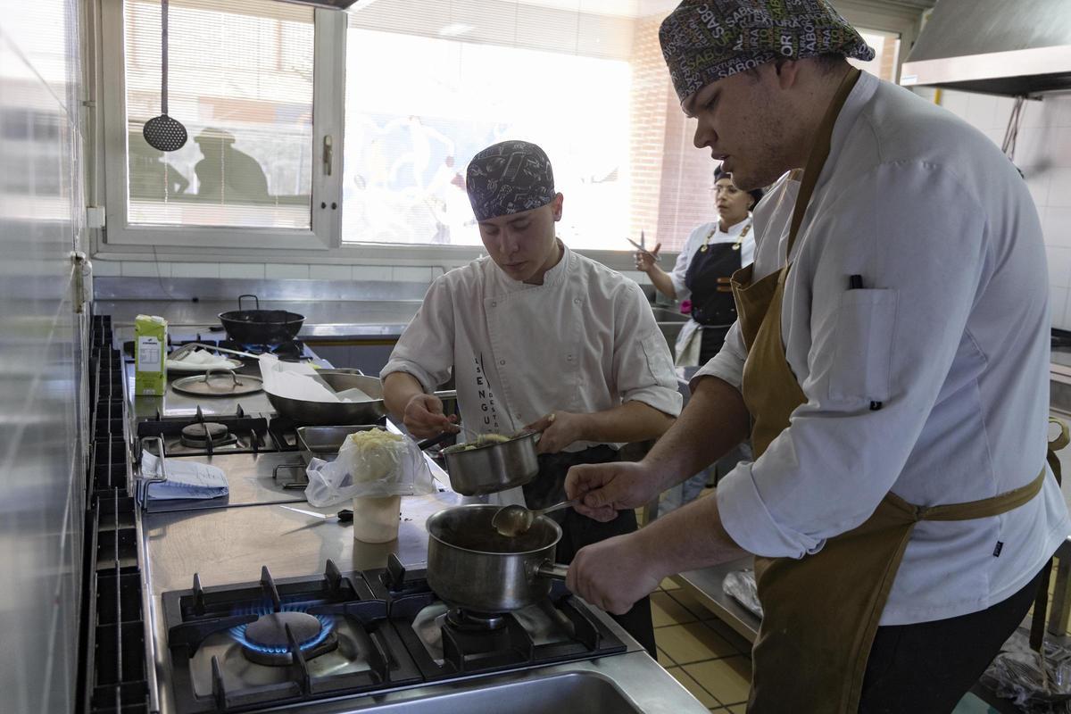 Estudiantes preparando uno de los platos en la cocina del restaurante del IES Enguera.
