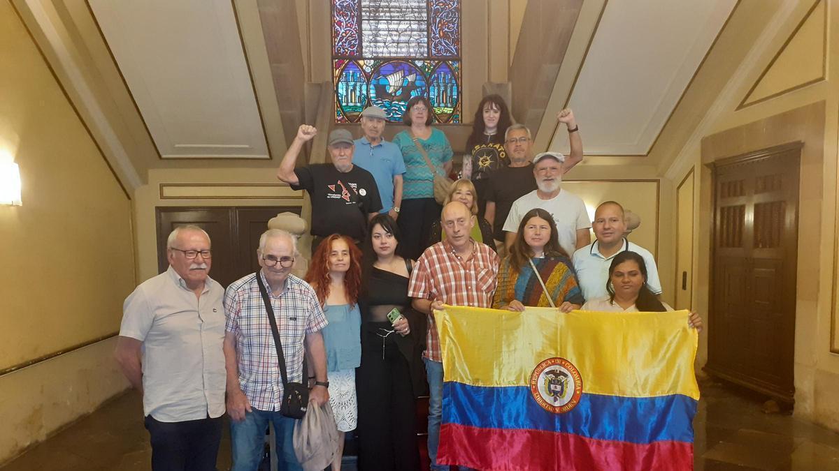 Los miembros del programa posan en las escaleras del Ayuntamiento con una bandera de su país.