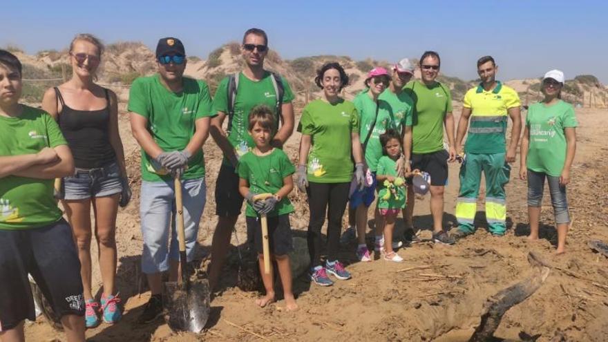 El grupo de voluntarios posa en la playa Moncayo tras completar su tarea de limpieza.