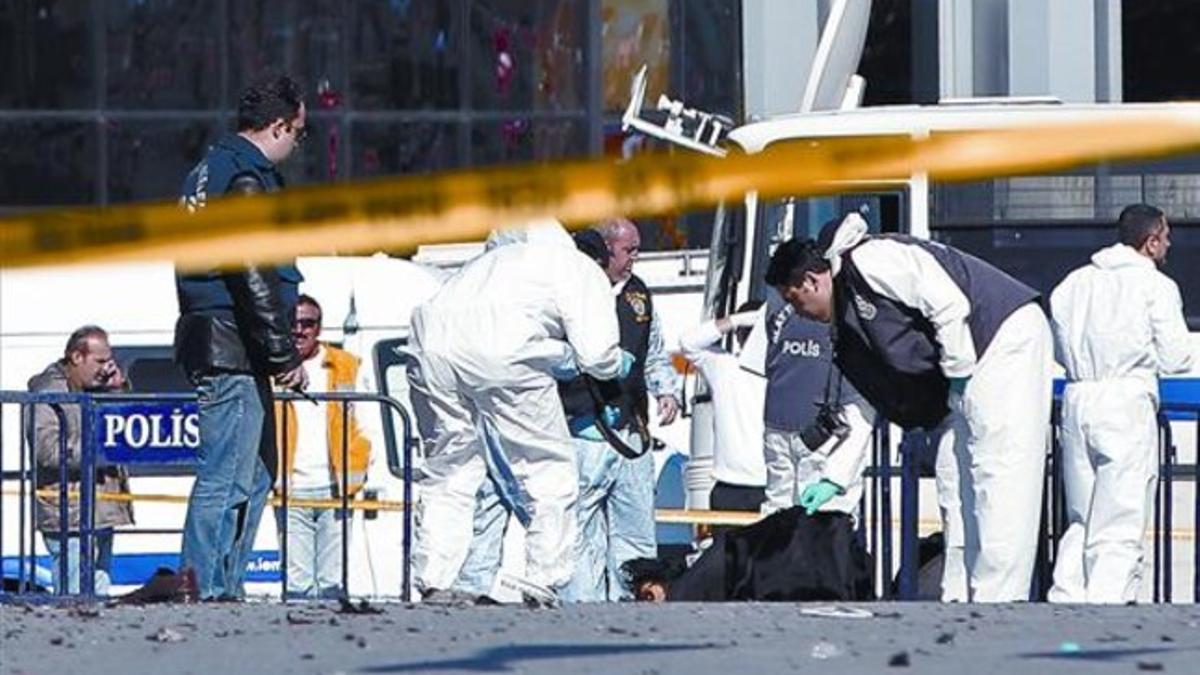 Agentes de la policía observan el cuerpo del hombre que detonó la bomba, ayer en la plaza de Taksim, en el centro de Estambul.