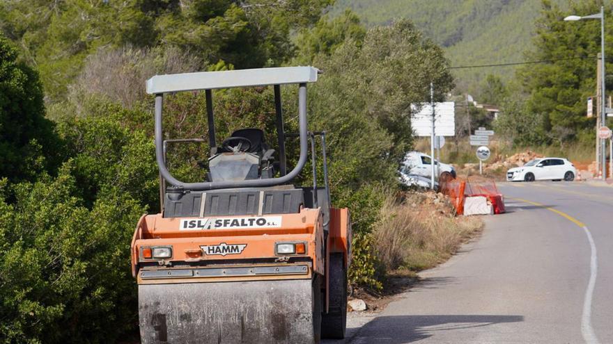 Operarios desbrozan una cuneta justo en el acceso y, a la derecha, una máquina en el arcén, a pocos metros del mismo punto de la carretera. | MARCELO SASTRE