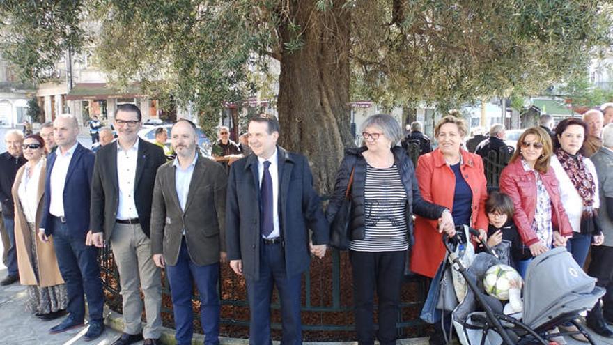 El alcalde y miembros de la corporación local rodean el árbol. // Concello