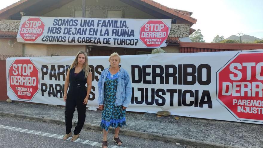 Jessica Iglesias, ayer tarde, con su abuela, ante la casa con sentencia de demolición en Chandebrito.