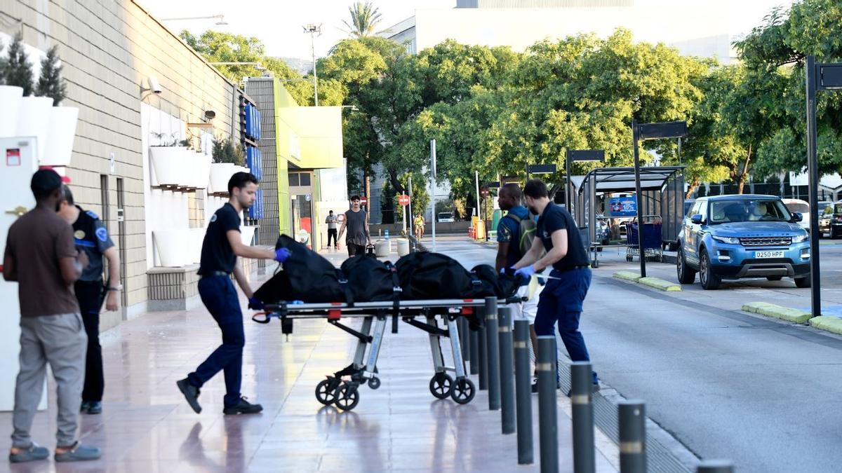 Dos trabajadores trasladan los restos mortales de la mujer, Gloria, al Instituto de Medicina Legal de Murcia, donde se le practicará la autopsia.