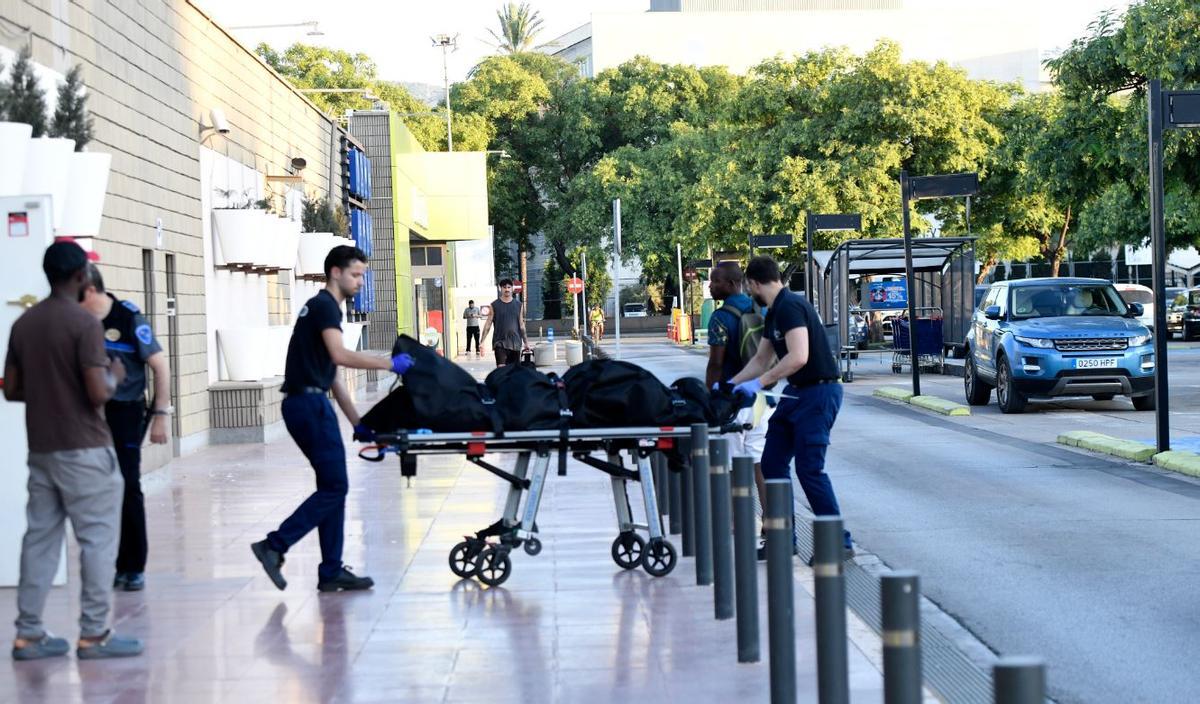Dos trabajadores trasladan los restos mortales de la mujer, Gloria, al Instituto de Medicina Legal de Murcia, donde se le practicará la autopsia.