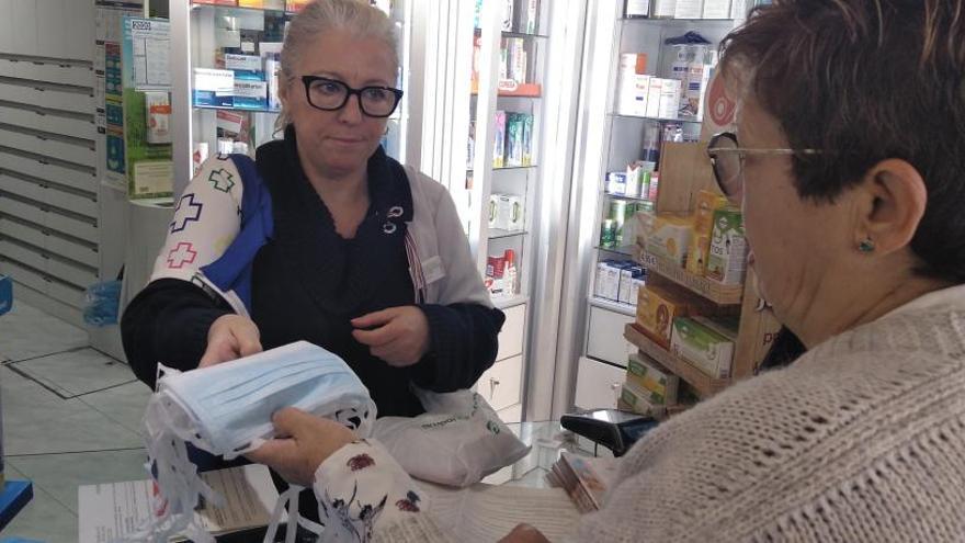 Una mujer se lleva varias mascarillas de una farmacia, ayer.