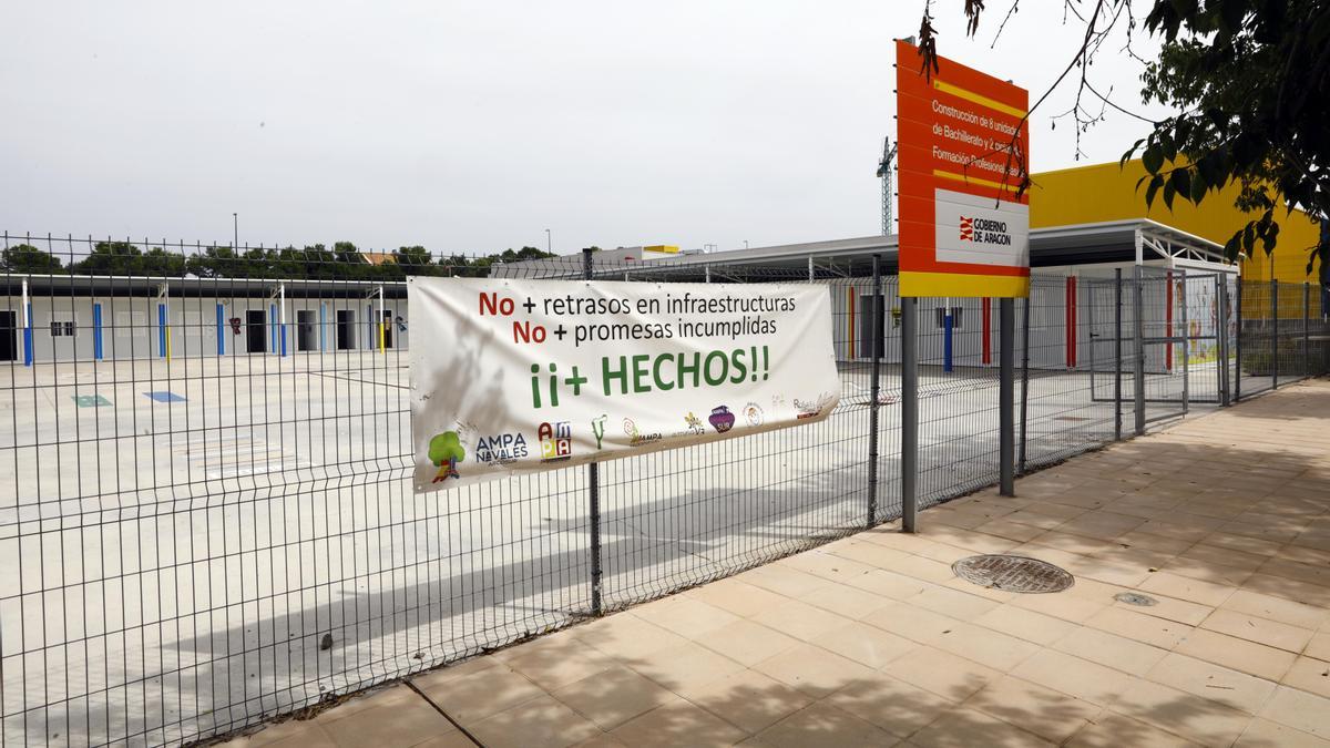 Obras en el colegio Soledad Puértolas de Valdespartera, con una pancarta reivindicativa instalada por la comunidad educativa.