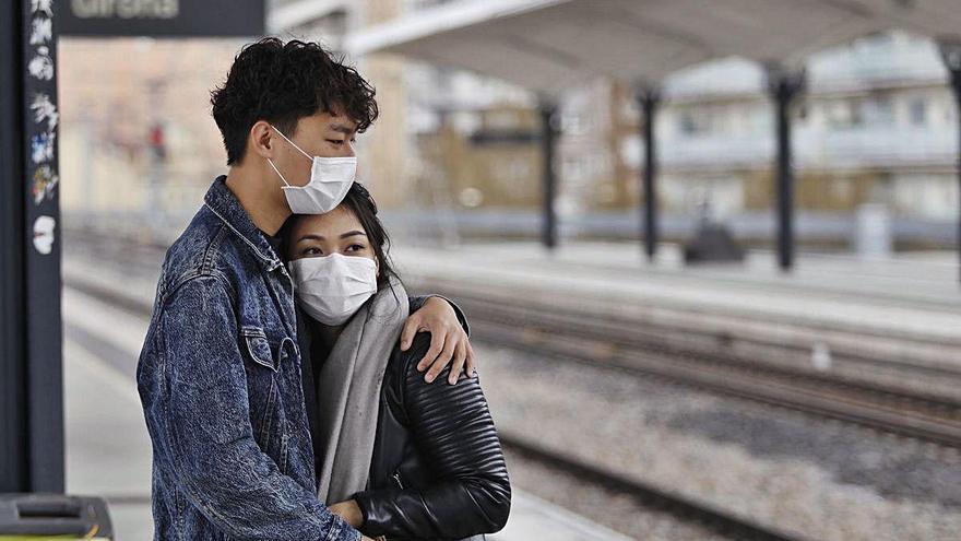 Dos joves enamoradament prudents a l&#039;estació de tren de Girona, en una imatge d&#039;arxiu.