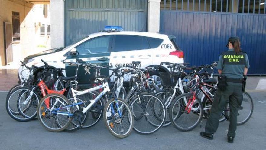 Una guardia civil junto a las bicicletas robadas que se han recuperado.