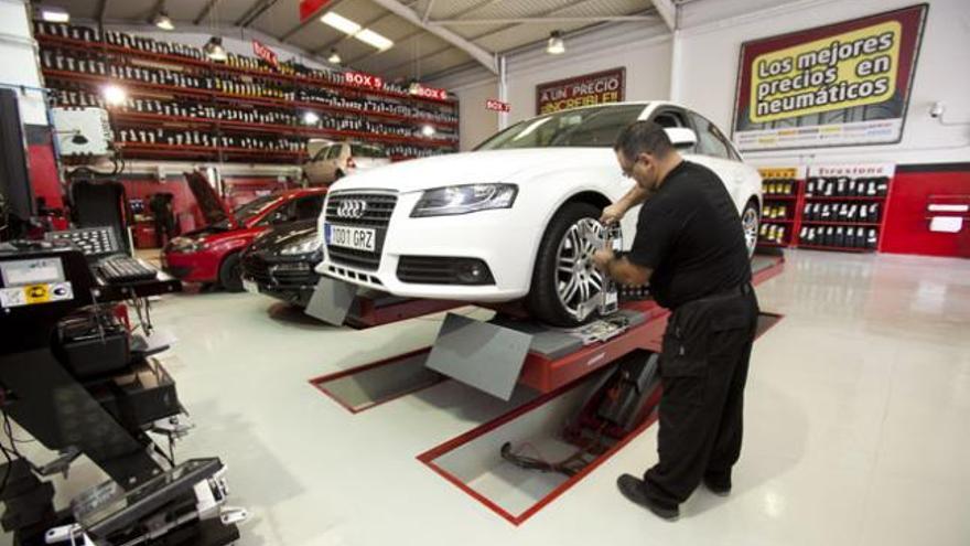 Uno de los mecánicos de Atlántico Autocentros chequeando las ruedas a un automóvil, ayer. | quique curbelo