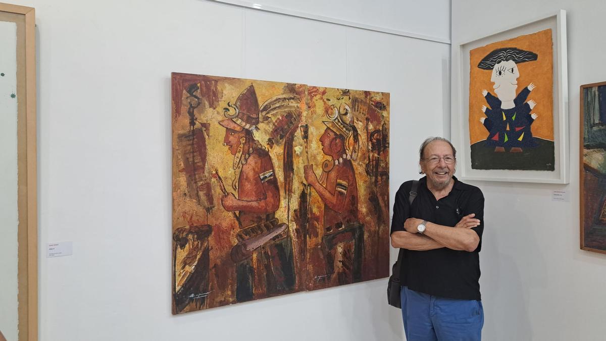 El pintor Antonio Espinar, en la exposición, junto a una de sus obras.