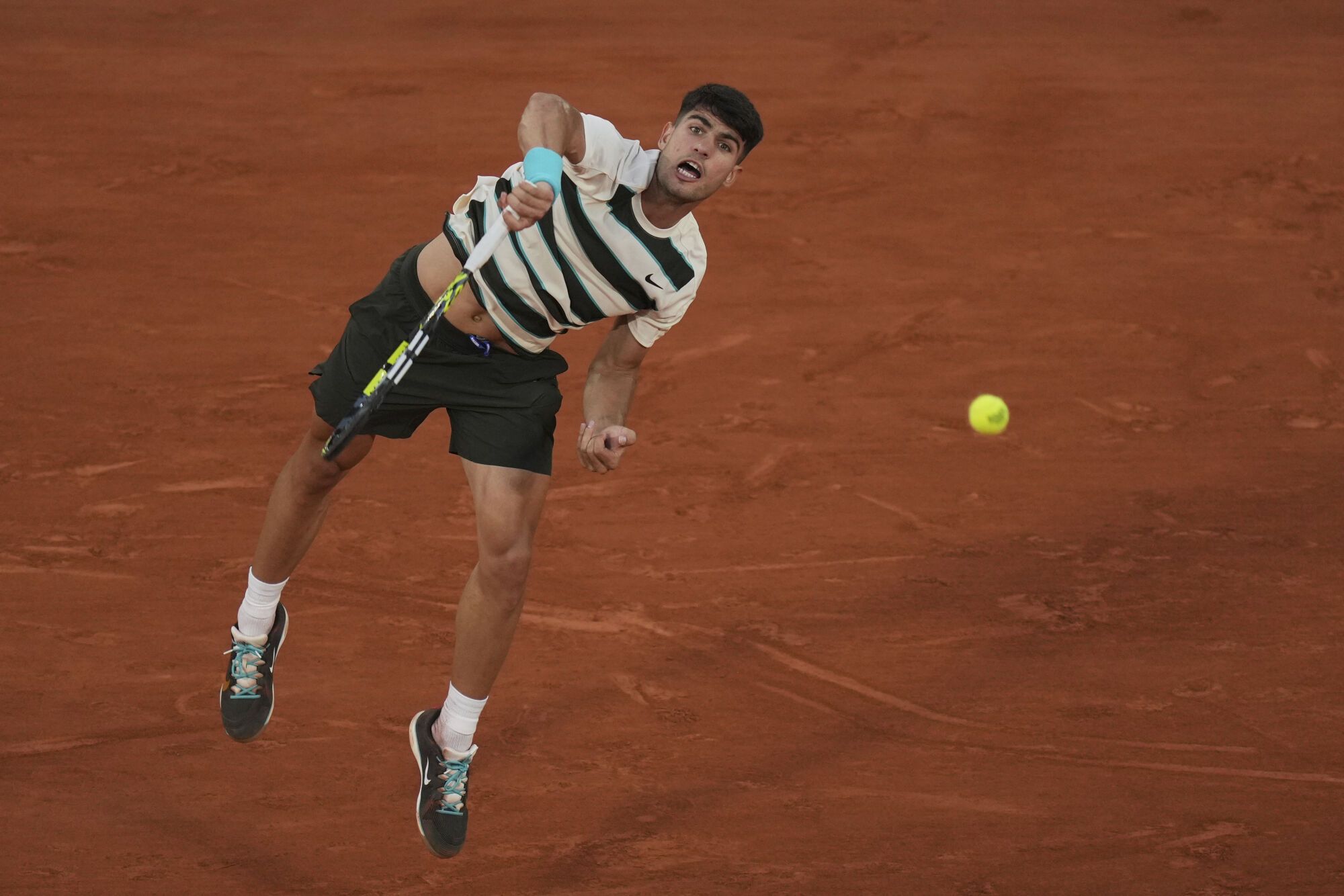 Spain's Carlos Alcaraz serves to Bosnia and Herzegovina's Damir Dzumhur during their third round match at the French Open tennis tournament at the Roland-Garros stadium, Friday, May 30, 2025, in Paris. (AP Photo/Thibault Camus)