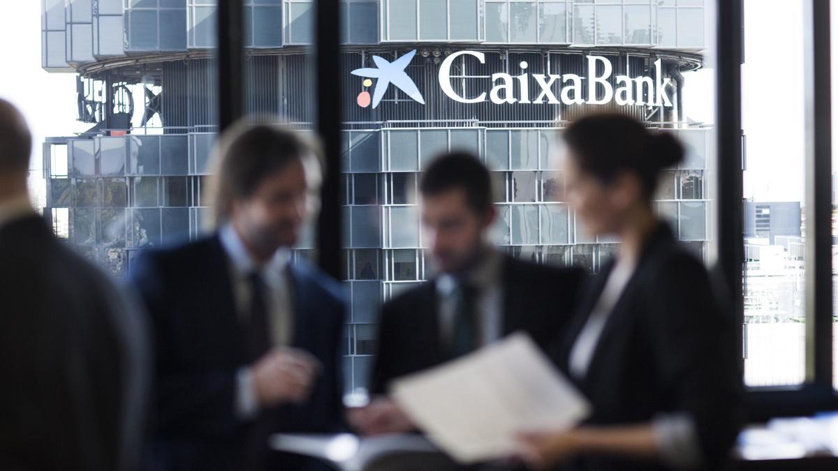 Varias personas con el logotipo de CaixaBank en el fondo.