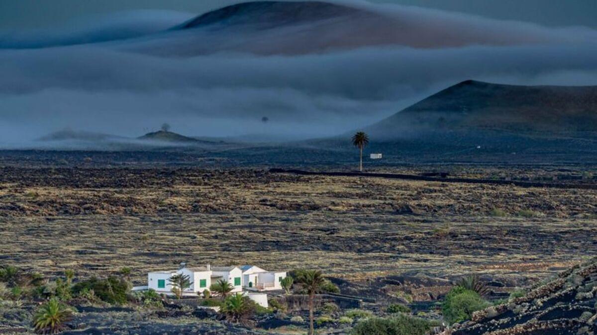 Tiempo en Canarias para el miércoles: 30 grados antes de la llegada de las lluvias. Brumas en el volcán de Tinache (al fondo), en Tinajo, vistas desde Masdache.