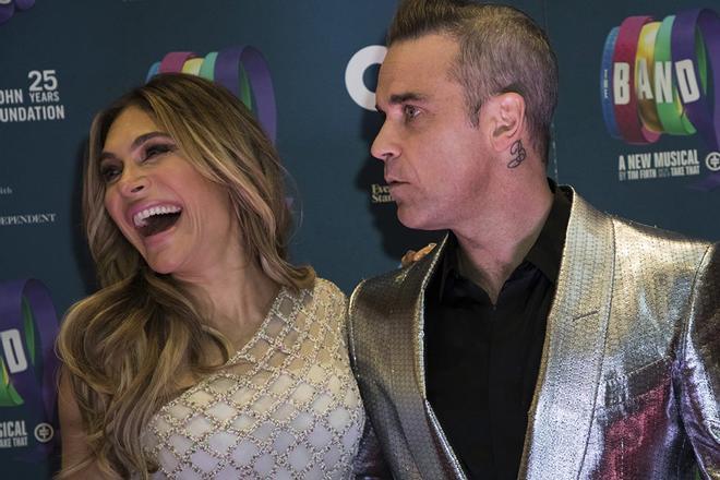 Robbie Williams, serio, y Ayda Field, muy feliz, posando