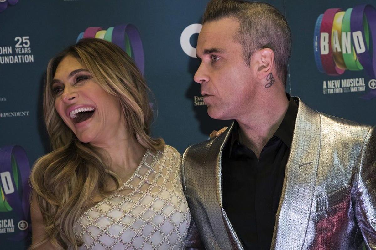 Robbie Williams, serio, y Ayda Field, muy feliz, posando