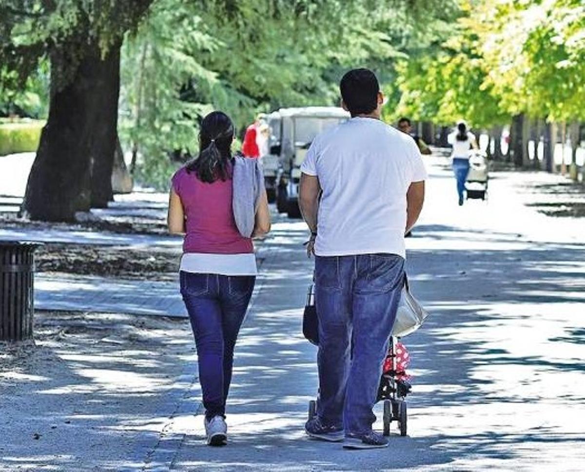 Una familia pasea por una zona verde.