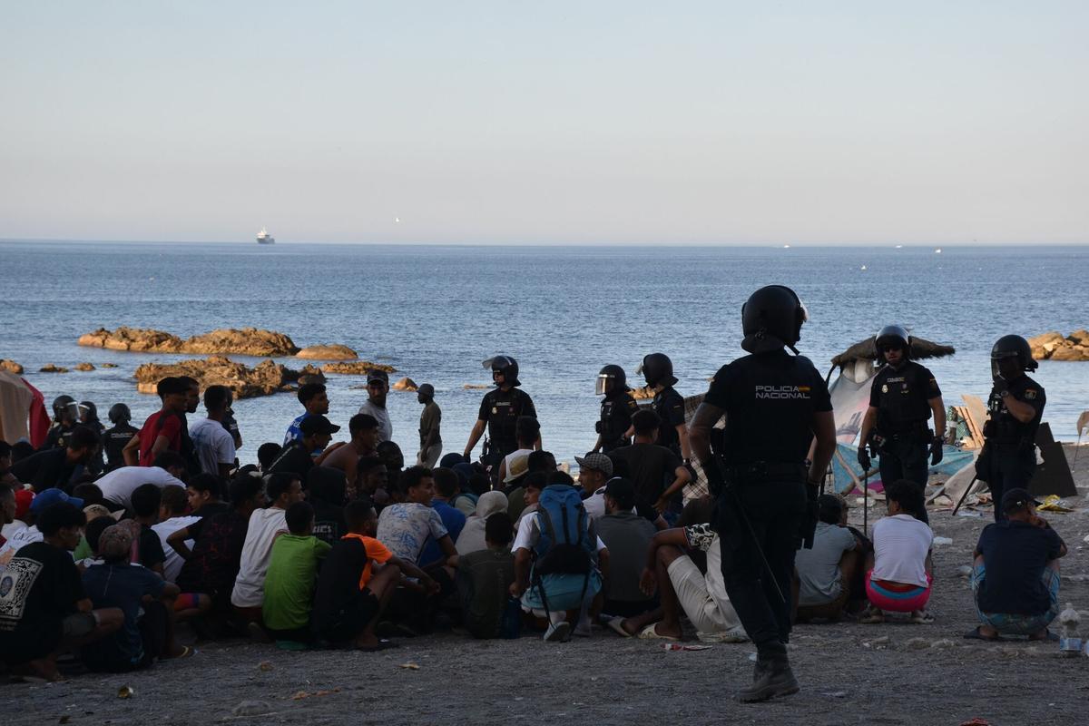 08/08/2026 Cientos de personas migrantes reciben atención sanitaria de profesionales del INGESA y voluntarios de Cruz Roja, en la playa del Trampolín, a 7 de agosto de 2026, en Ceuta (España). Profesionales del Instituto Nacional de Gestión Sanitaria (INGESA) y voluntarios de Cruz Roja ofrecen atención sanitaria y reparten alimentos a cientos de migrantes bajo la coordinación de antidisturbios de la Policía Nacional. POLITICA Gabriela Sardá Núñez - Europa Press
