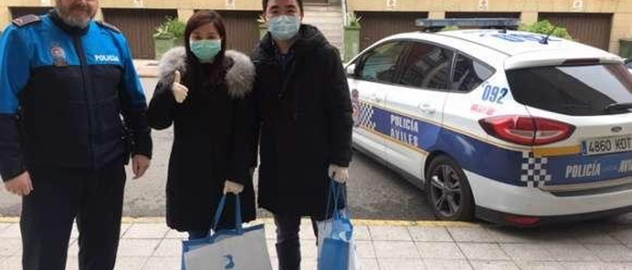 Un subinspector de la Policía Local de Avilés, con dos ciudadanos que acudieron ayer al cuartel a donar material de protección.