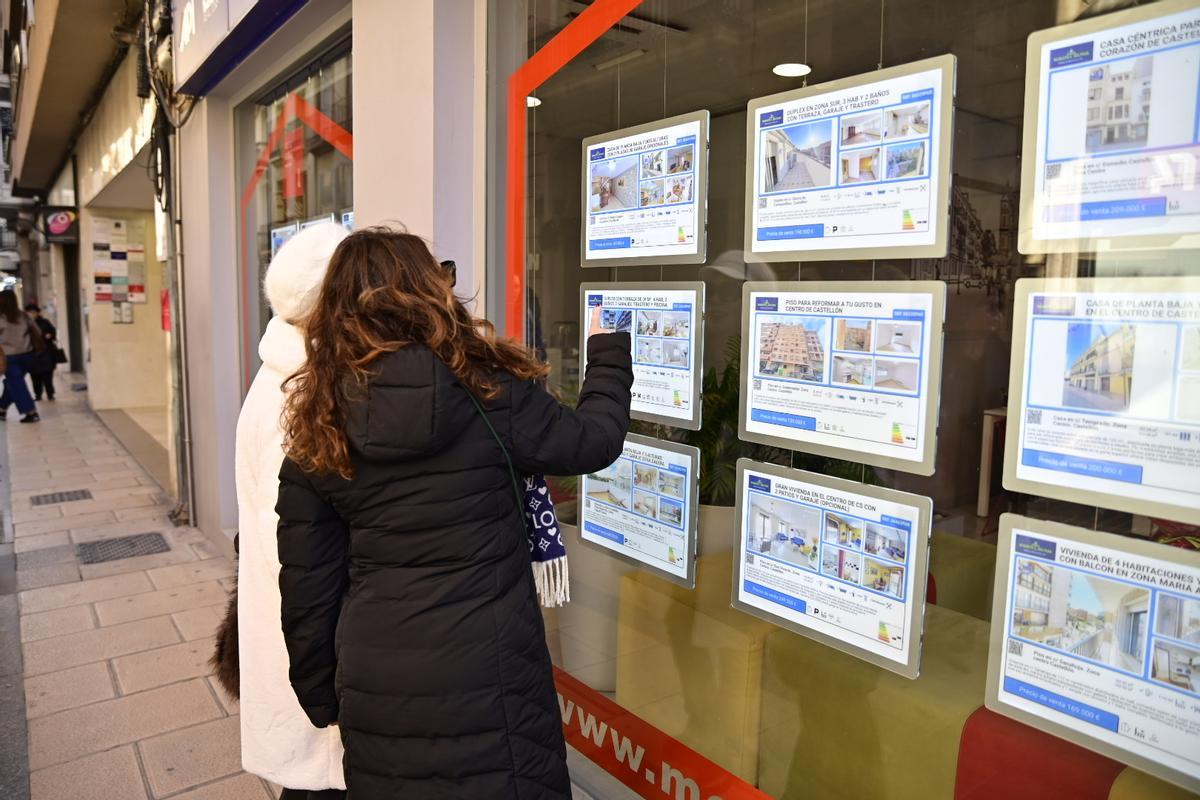 Dos mujeres consultan ofertas en una inmobiliaria de Castelló.