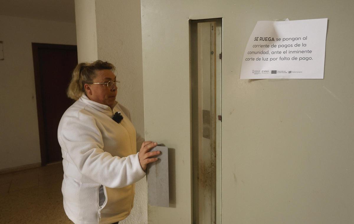 Maria del Mar abre la puerta del ascensor de su finca con la advertencia de la Generalitat Valenciana de corte de luz.