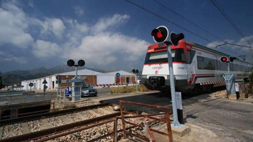 Un coche espera en el paso a nivel de Xeresa.