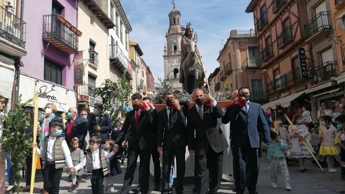 Cargadores portan a hombros la imagen de &quot;La Borriquilla&quot; a su paso por la calle Corredera