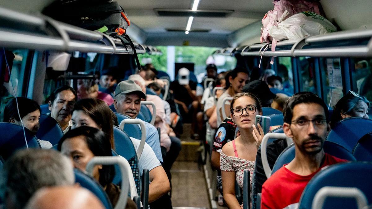 Personas desalojadas del municipio de Aldea del Fresno viajan en autobús, en Villamanta