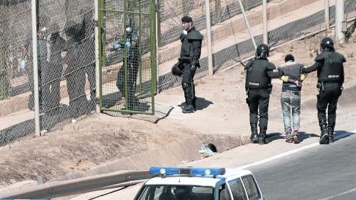 Unos guardias civiles conducen a un grupo de malienses al otro lado de la valla, el pasado 13 de agosto.