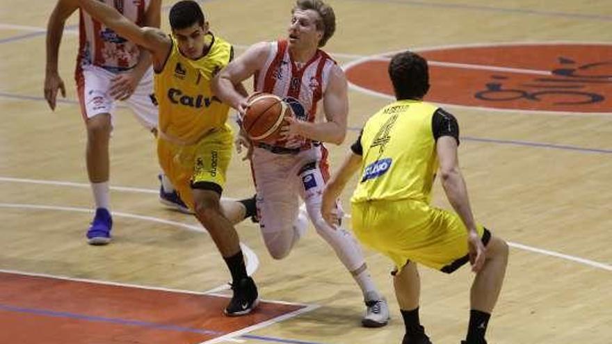 Pablo Bretón, del Gijón Basket, entra a canasta ante la oposición de dos jugadores gallegos.