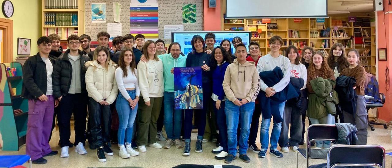 Teresa Álvarez, con el cartel de la Semana Santa 2024, rodeada de los alumnos que acudieron a su charla en la biblioteca del IES Maestro Haedo. | Cedida