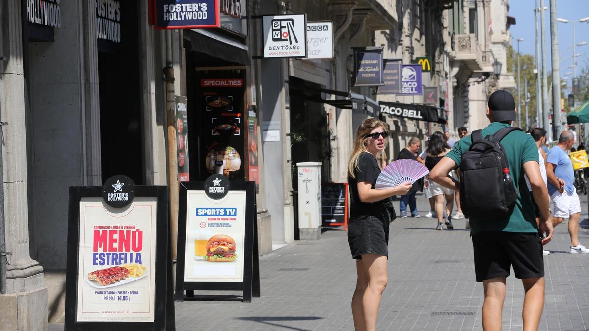 Una calle de Barcelona con varios restaurantes que crecen mediante la franquicia