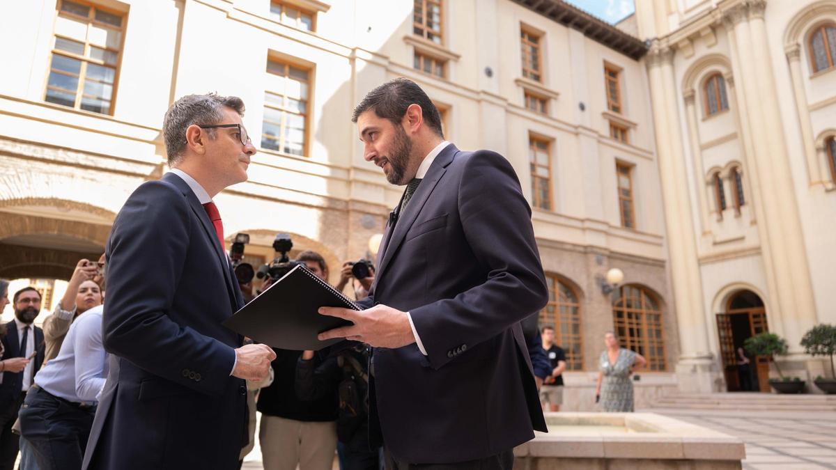 El vicepresidente Nolasco, con un micrófono de solapa, conversa con el ministro Bolaños, este jueves en el Pignatelli.