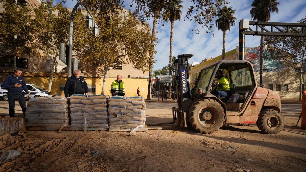 Operarios municipales de la localidad de Aldaia montan muros de contención con sacos de arena.