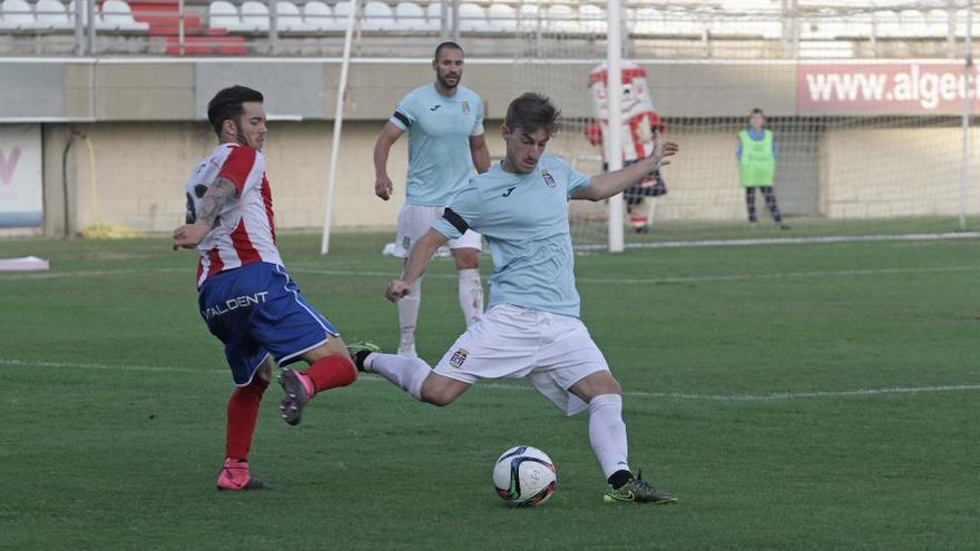 Quique Rivero se dispone a lanzar en largo la pelota ante la presencia de un jugador del Algeciras.