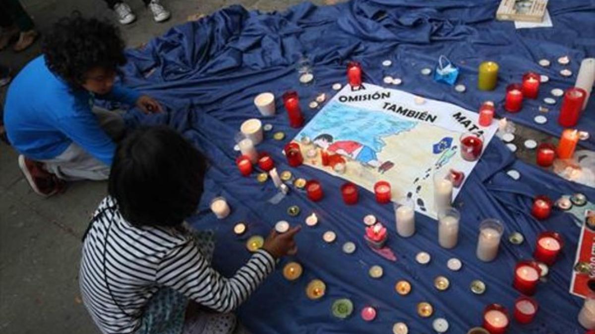 'Mare mortum' 8 Dos niños colocan velas sobre un manto azul que simboliza el Mediterráneo, ayer, en la concentración.