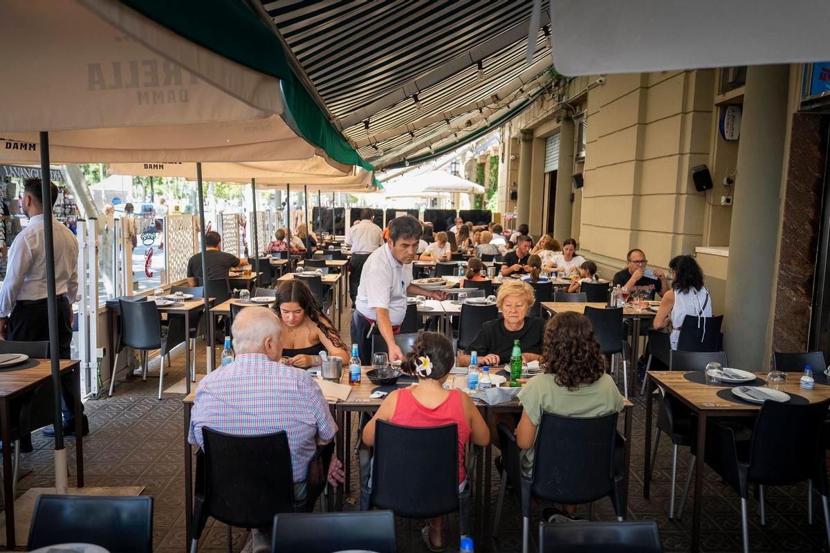 Clientes consumen bebidas en la terraza de un restaurante de Barcelona.