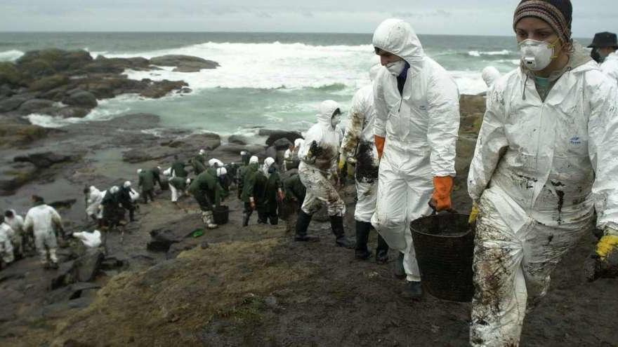 Voluntarios limpian la costa en Muxía (A Coruña). // Lavandeira Jr. (Efe)