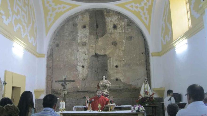 Un oficio religioso en la iglesia de Barcial del Barco. Al fondo, el muro donde estaba el retablo.