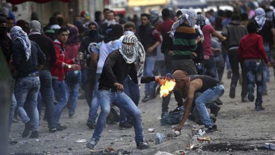 Un manifestante palestino lanza un cóctel molotov contra soldados israelíes durante un choque en la localidad cisjordana de Hebrón.