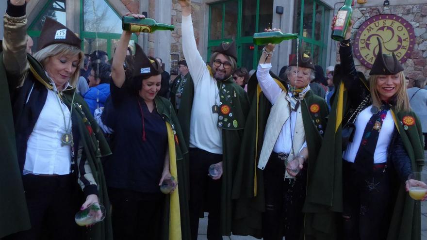 Miembros de la Cofradía de los Siceratores, escanciando delante del Museo de la Sidra de Asturias, en Nava.